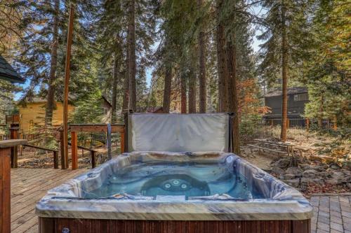 a jacuzzi tub on a deck in the woods at Serene 5BDR Near Beach and Forest Trails in Carnelian Bay