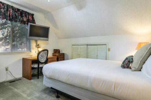 a bedroom with a bed and a desk and a television at Serene 5BDR Near Beach and Forest Trails in Carnelian Bay