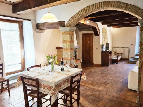 ein Esszimmer mit einem Tisch und einem Kamin in der Unterkunft Studio für 7 Personen ca 90 qm in Pratovecchio, Toskana Provinz Arezzo in Pratovecchio