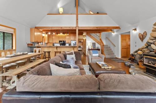 ein großes Wohnzimmer mit Couch und Tisch in der Unterkunft Tranquil Tahoe A-Frame Walk to Beach in Tahoe Vista
