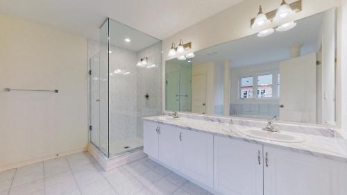 a bathroom with two sinks and a glass shower at 4-Bedroom Serenity Retreat - Comfort & Style in Brampton