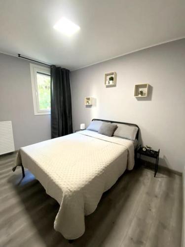 une chambre avec un grand lit blanc dans une pièce dans l'établissement Charmante T3 sur la Côte d’Azur, à Nice