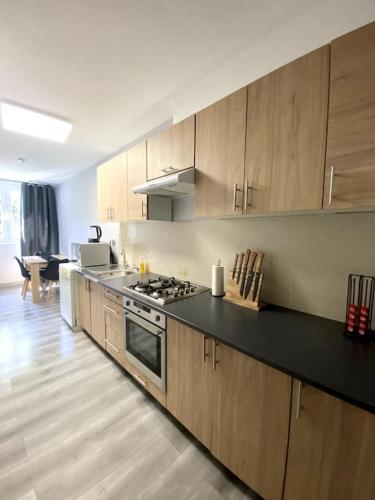 une cuisine avec des armoires en bois et un four à plaques de cuisson dans l'établissement Charmante T3 sur la Côte d’Azur, à Nice