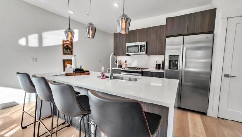 a kitchen with a counter with chairs and a refrigerator at 2BDR New Build Minutes to Dillon Reservoir in Silverthorne