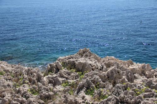 a pile of rocks next to the ocean at Hôtel La Villa Patricia - Charme et Tradition in Villefranche-sur-Mer