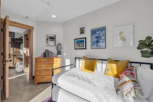 a bedroom with a white bed with yellow pillows at 2BD Near Slopes and Town with Impressive Views in Park City