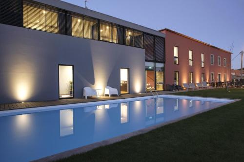 una piscina frente a un edificio por la noche en Casa de l Cura, en Miranda do Douro