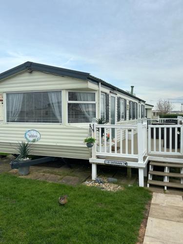 a white mobile home with a porch and a deck at 8 berth Waterside Ingoldmells V8 Santanavan 3 in Skegness