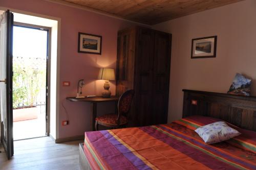 a bedroom with a bed and a desk and a window at Affittacamere Belvedere in Sordevolo