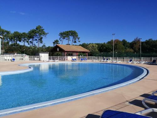einen großen Pool mit Stühlen und einem Pavillon in der Unterkunft Villa Atlantis 4-8 pers super équipée proche océan in Soustons