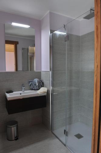 a bathroom with a glass shower and a sink at Affittacamere Belvedere in Sordevolo