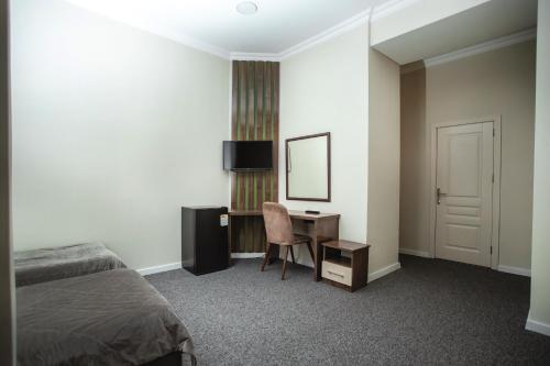 a bedroom with a bed and a desk and a mirror at Moss Art Boutique Hotel in Baku