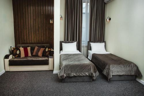 a hotel room with two beds and a couch at Moss Art Boutique Hotel in Baku