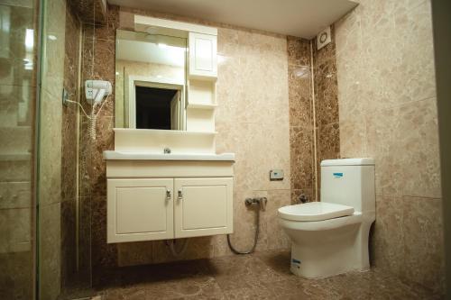a bathroom with a toilet and a shower and a mirror at Moss Art Boutique Hotel in Baku