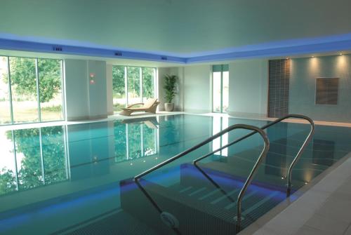 a swimming pool with a glass floor in a house at De Vere Cotswold Water Park in Cirencester