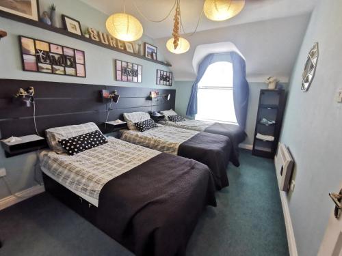 Cette chambre comprend 2 lits et une fenêtre. dans l'établissement Sandy Cove Bundoran Sea Views Free Wifi Netflix Luxurious Apartment, à Bundoran