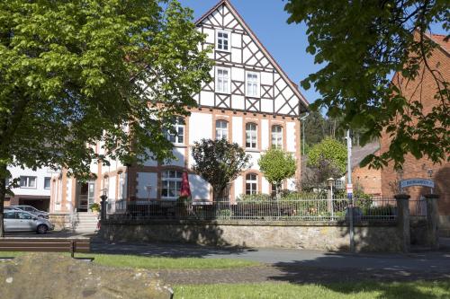 a building with a fence in front of it at Gasthaus Hotel Pfeifferling in Wolfhagen