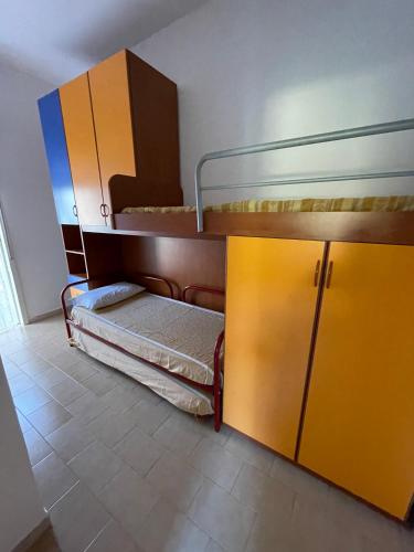 a room with two bunk beds and a cabinet at Villa Acacie Capì in Villaggio San Leonardo