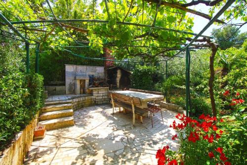 d'une terrasse avec une table et une cheminée dans le jardin. dans l'établissement Ferienwohnung für 6 Personen ca 110 qm in Banjole, Istrien Istrische Riviera, à Banjole