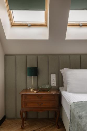 a bedroom with a bed and a table with a lamp at Arte Gdańsk in Gdańsk