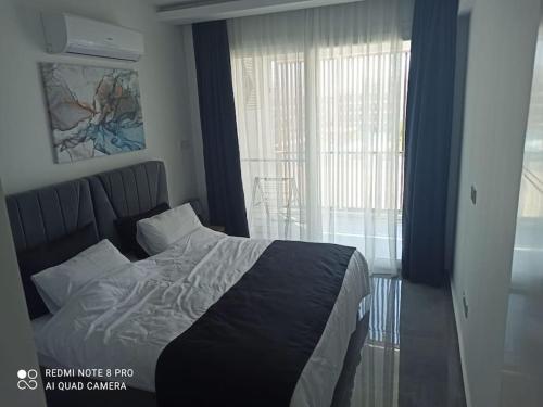 a bedroom with a bed and a large window at Comfy, Luxury Flat for All Ages in Iskele