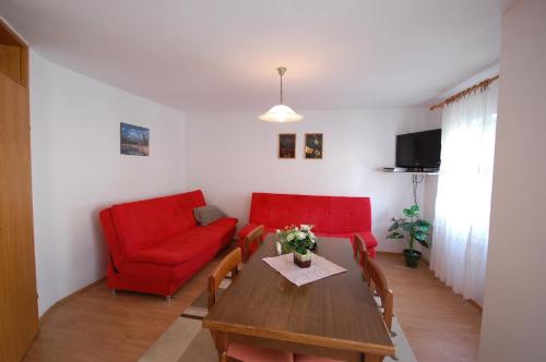 een woonkamer met een rode bank en een tafel bij Ferienwohnung für 4 Personen ca 37 qm in Njivice, Kvarner Bucht Krk - b58789 in Njivice