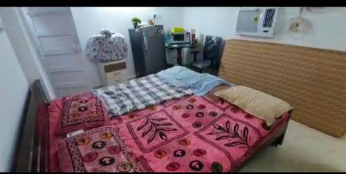 1 dormitorio con 1 cama grande con manta rosa en Halls Tower, en Chennai