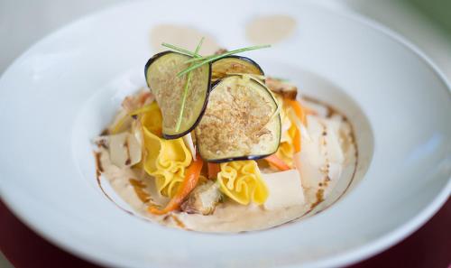 a bowl of soup with vegetables and cheese at Hotel Boutique Edelweiss La Garriga in La Garriga