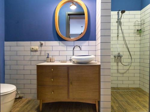 y baño con lavabo y espejo. en Wehost Pool and Gym Apartment, en Tiflis