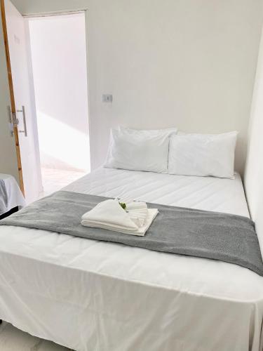 a white bed with a towel on top of it at Pousada Velho Brito in Piranhas