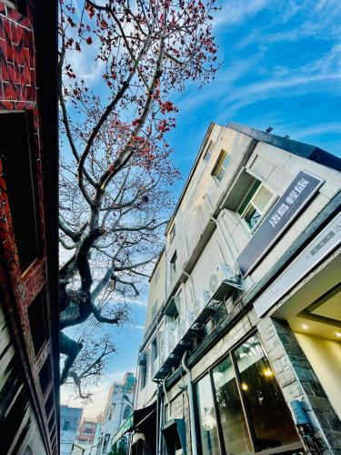 un edificio al lado de una calle con un árbol en WDbnb, en Jincheng