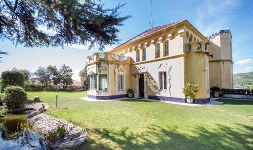 an oldstyle house with a large yard with grass at Hotel Boutique Edelweiss La Garriga in La Garriga