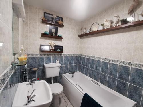 ein Badezimmer mit einer Badewanne, einem WC und einem Waschbecken in der Unterkunft Seashell Cove Bundoran Luxurious Sea View Free Wifi Netflix Sleeps 5 in Bundoran