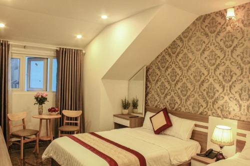 um quarto de hotel com uma cama, uma mesa e cadeiras em Tiến Anhh 1 em Da Lat