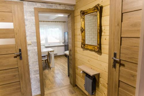 baño con paredes de madera y espejo en la pared en Domek Pod Klonem Agroturystyka, en Białowieża