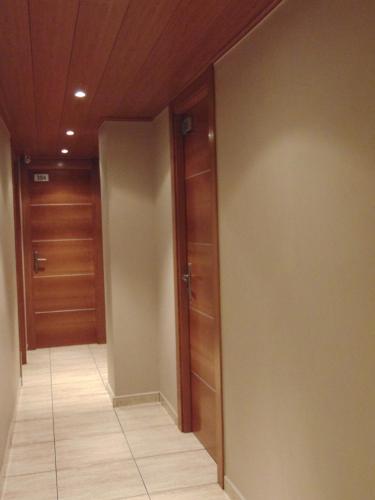 a hallway with wooden doors and a tile floor at Hostal Piteus in Sant Llorenc de Morunys
