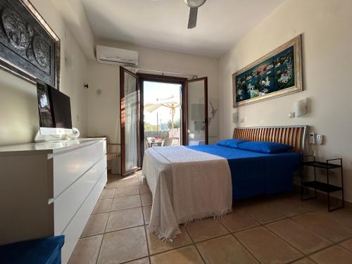 1 dormitorio con cama azul y balcón en Villa LP Kokkino Chorio en Vamos