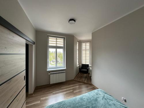 a bedroom with a bed and a window at Apartament Zamkowa 14 in Węgorzewo