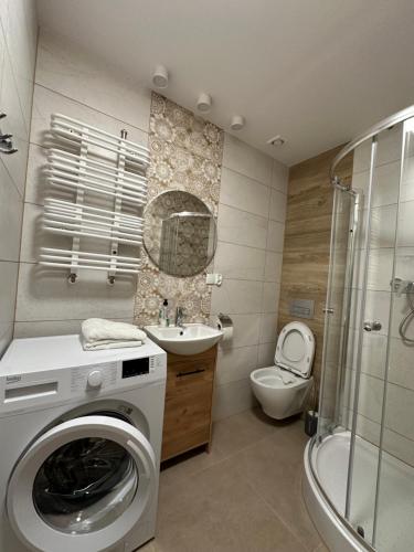 uma casa de banho com uma máquina de lavar roupa e um WC em Apartament Zamkowa 14 em Węgorzewo