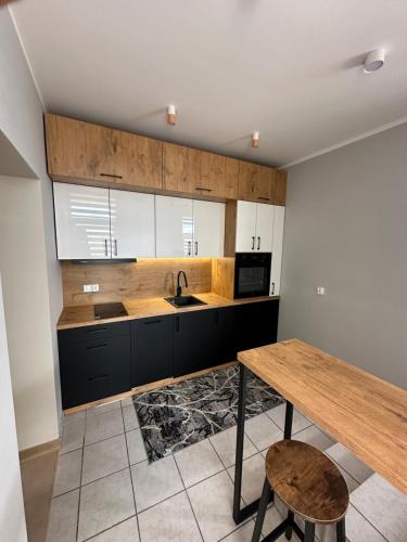a kitchen with a wooden table and a sink at Apartament Zamkowa 14 in Węgorzewo