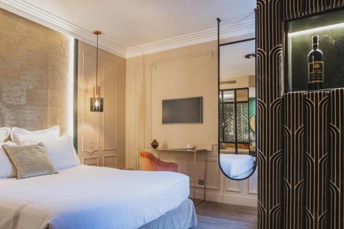 a hotel room with a bed and a mirror at Hôtel Singulier Bordeaux - Boutique Hôtel & Spa Anne Semonin in Bordeaux