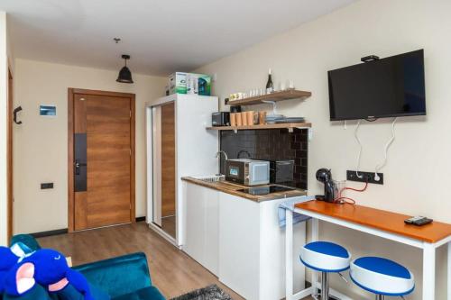 a kitchen with a refrigerator and a table and chairs at Stylish Studio Apartment with balcony in Gudauri