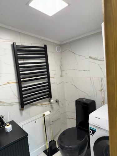 a bathroom with a black toilet and a window at LUX HOUSE Roztocze Sauna i Bania z hydromasażem in Krasnobród