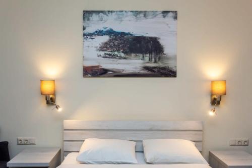 1 dormitorio con 1 cama y una pintura en la pared en Cozy Studio Ski In Out Apartment In New Gudauri en Gudauri