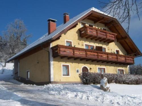 a house with a balcony in the snow at Ferienwohnung für 4 Personen ca 50 qm in Bleiburg, Kärnten Unterkärnten in Bleiburg