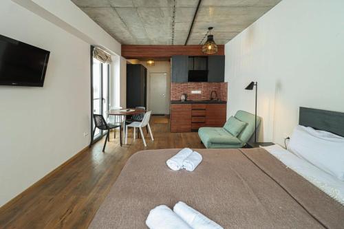 a bedroom with a bed and a living room at New Gudaur Studio with Balcony By Wehost in Gudauri