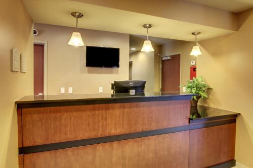 a lobby with a reception desk with a flat screen tv at Cobblestone Inn & Suites - Hartington in Hartington