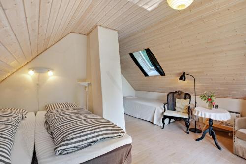 a attic bedroom with two beds and a table at Amalies Annex in Sorø