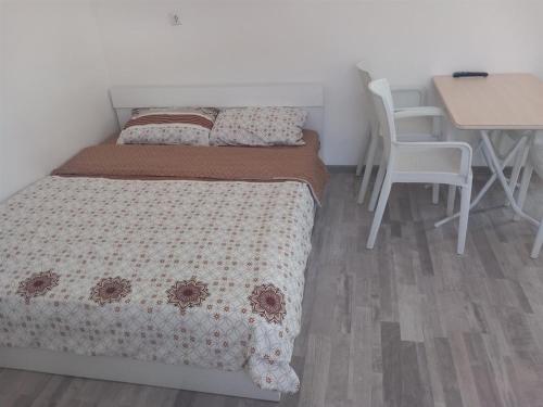een slaapkamer met een bed en een tafel en stoelen bij Apartment Hristef in Ljubaništa