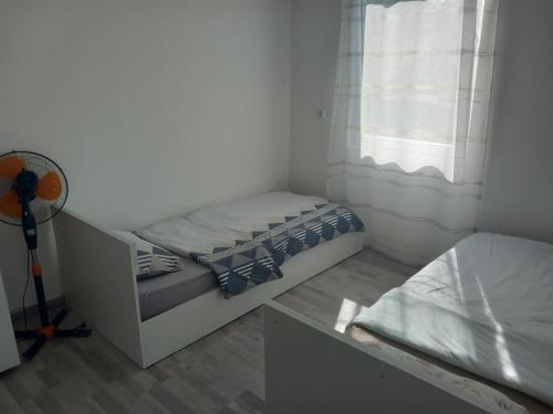 een kleine slaapkamer met een bed en een raam bij Apartment Hristef in Ljubaništa